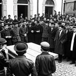 **Prompt:** A historical image depicting the founding of ETA in 1959 during the Franco dictatorship, with Basque youth gathering in a clandestine meeting, expressing a desire for change. The atmosphere is tense and oppressive, reflecting the suppression of Basque culture and political rights at the time. Style: Dramatic, black and white photograph.